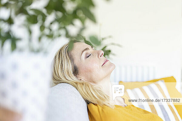Woman with eyes closed relaxing at home