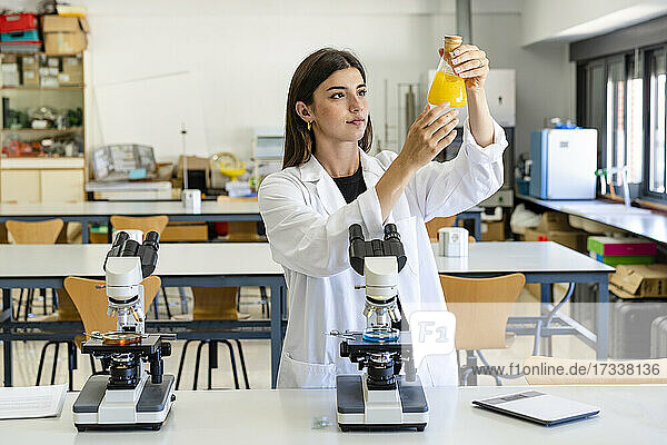 Wissenschaftlerin bei der Untersuchung einer Chemikalie in einem Kolben im Labor