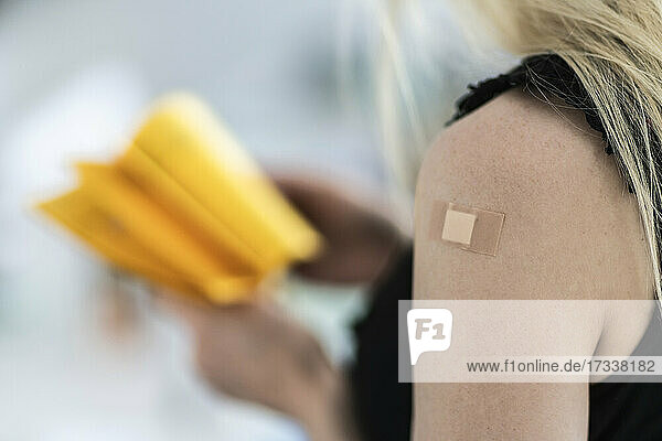 Frau mit Verband am Arm im Impfzentrum