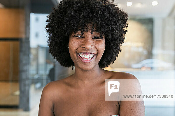 Schöne junge Frau mit Afrofrisur lachend