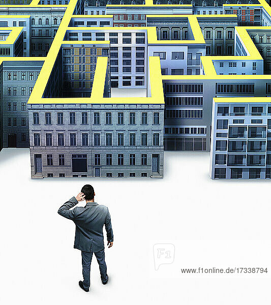 Geschäftsmann kratzt sich vor dem Gebäudelabyrinth der Stadt am Kopf