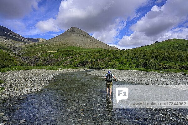 Woman crossing a stream  hiking Morsardalur  Skaftafell NP  Austurland  Iceland  Europe