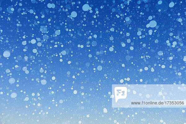 Falling snow against blue background
