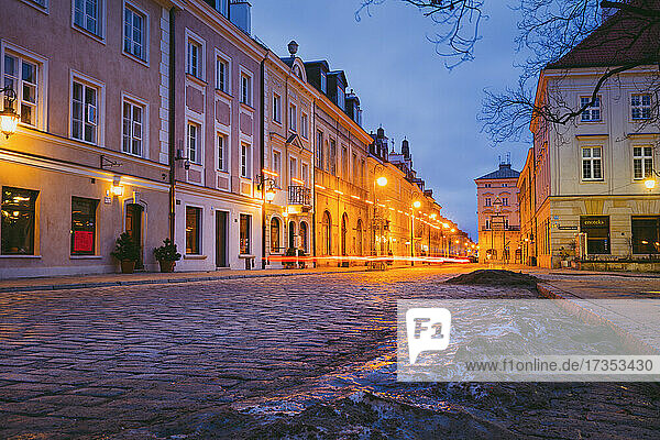 Poland  Masovia  Warsaw  Townhouses along cobblestone street in old town at night