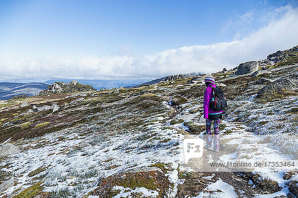 Australia  New South Wales  Woman hiking in snowy mountains in Kosciuszko National Park