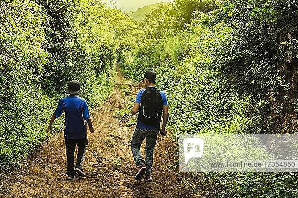 Zwei Männer auf einem Weg durch die Landschaft  Zwei junge Männer auf einem Weg mit Kopierraum Rivas  Nicaragua  Mittelamerika