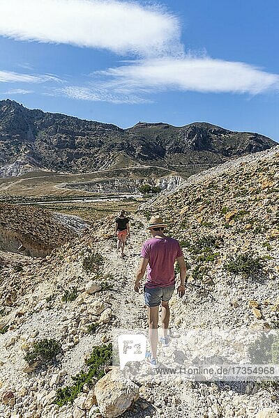 Three tourists hiking in a volcanic caldera with pumice fields  yellow coloured sulphur stones  Alexandros crater  Nisyros  Dodecanese  Greece  Europe