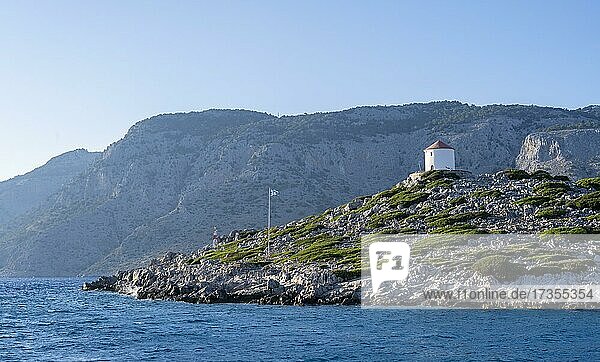 Alte Windmühle auf einem Felsen mit griechischer Flagge  Bucht von Panormitis  Simi  Dodekanes  Griechenland  Europa