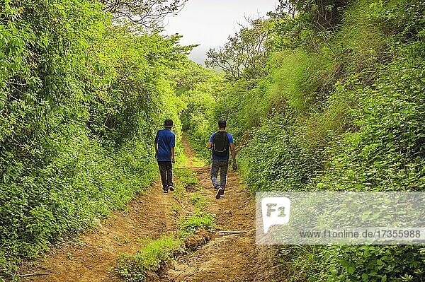 Two men on a path through the countryside  Two young men walking along a path with copy space Rivas  Nicaragua  Central America