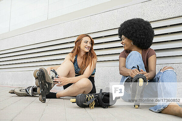 Glückliche Freundinnen auf Inline-Skates auf dem Fußweg