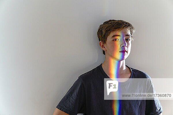 Boy with spectrum on face in front of wall