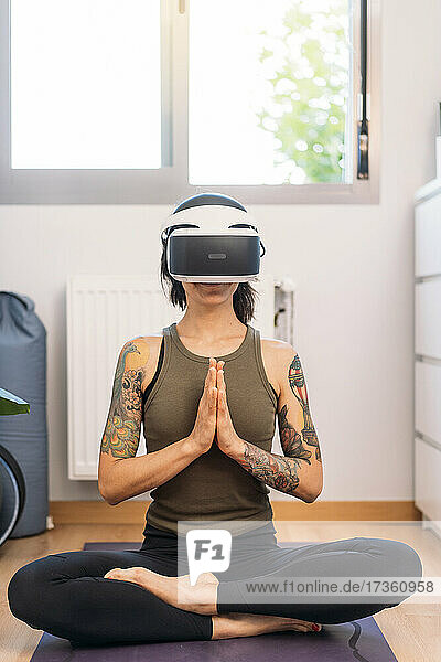 Frau meditiert mit einem Virtual-Reality-Headset zu Hause