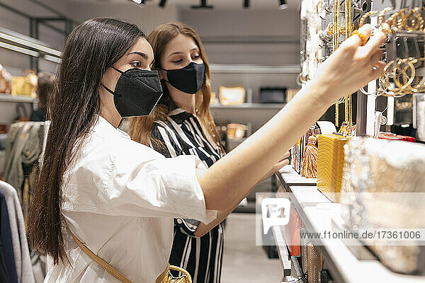 Freundinnen prüfen Schmuck beim Einkaufen im Einkaufszentrum
