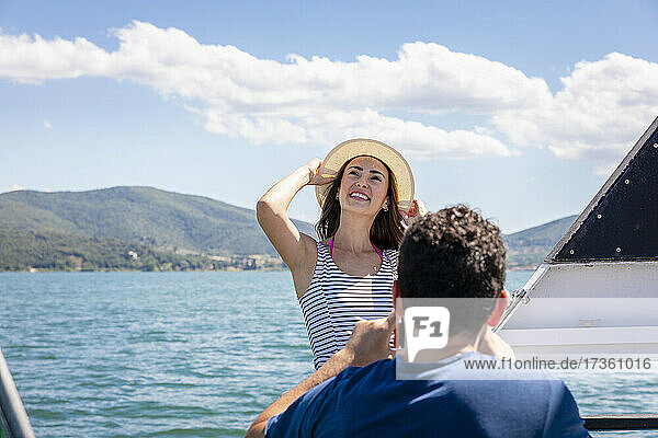 Man with happy young girlfriend at tourboat on sunny day