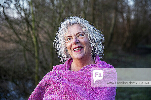 Lächelnde Frau mit Handtuch in der Natur
