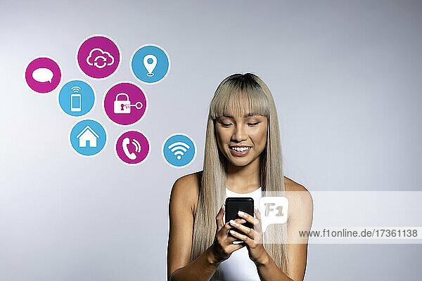 Blonde Frau nutzt Apps auf einem Smartphone auf weißem Hintergrund