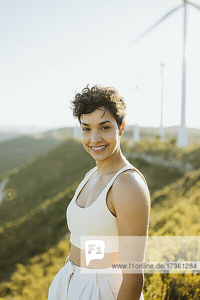 Lächelnde Frau auf einem Berg stehend