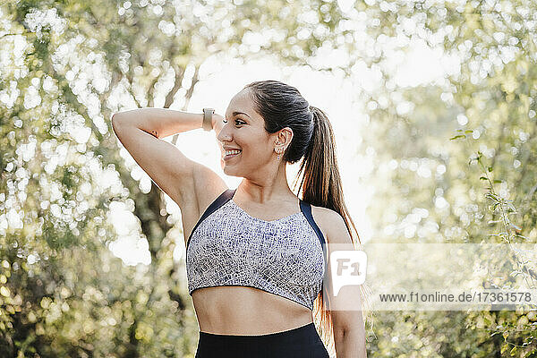 Lächelnde Sportlerin beim Muskeltraining im Wald