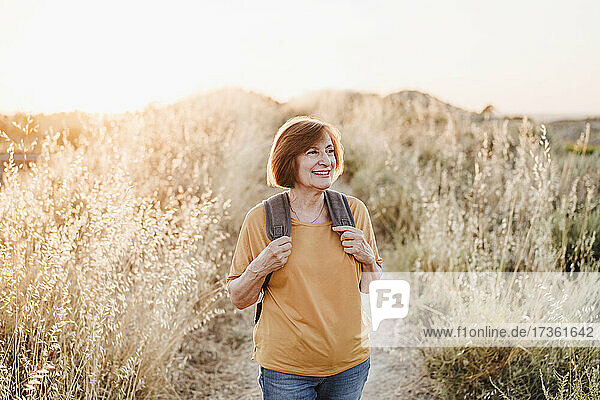 Smiling senior woman looking away while hiking