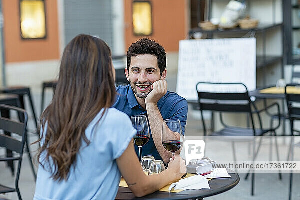 Mann mit Hand am Kinn im Gespräch mit Freundin im Restaurant