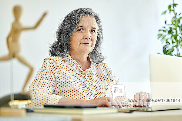 Businesswoman with laptop at desk in office
