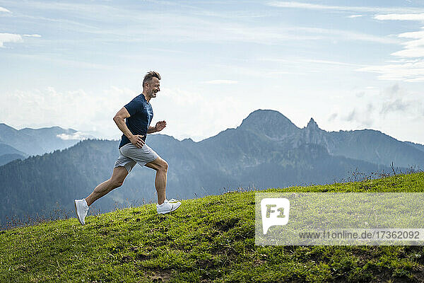 Smiling mature man running on mountain