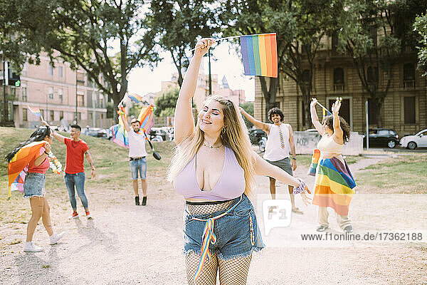Young woman in pride event with friends at park