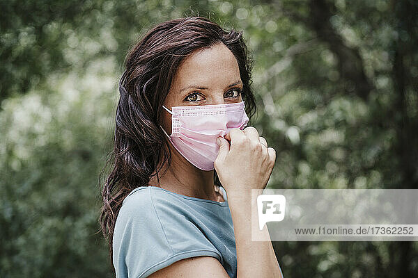 Frau mit Gesichtsschutzmaske im Wald während COVID-19