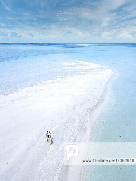 Luftaufnahme eines jungen Paares  das zusammen am Sandstrand der Insel Thulusdhoo steht