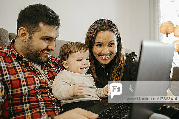 Happy family during video call through laptop at home