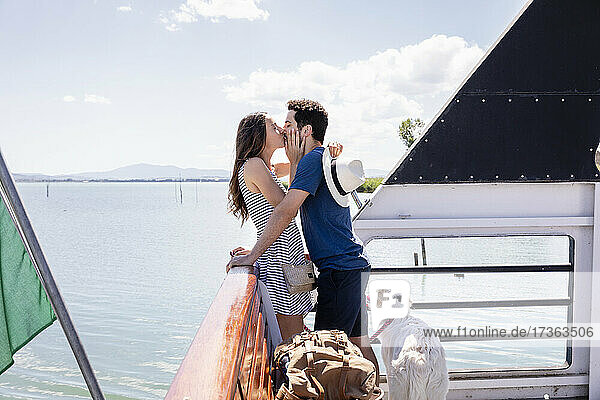 Couple kissing each other while standing at ferry boat