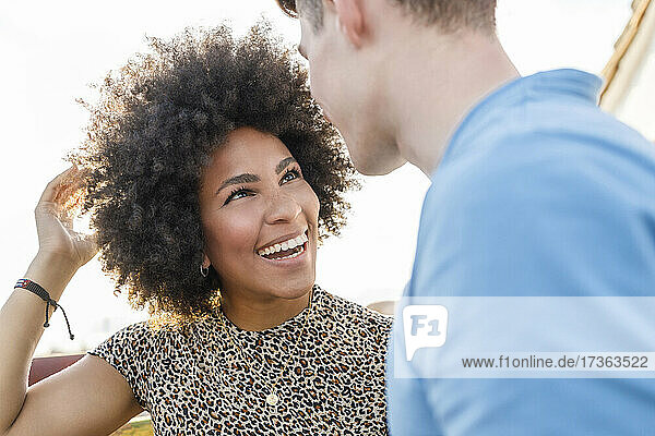 Glückliche junge Frau im Gespräch mit ihrem Freund auf dem Dach