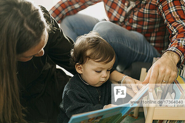 Eltern lesen ihrem Sohn zu Hause ein Buch vor