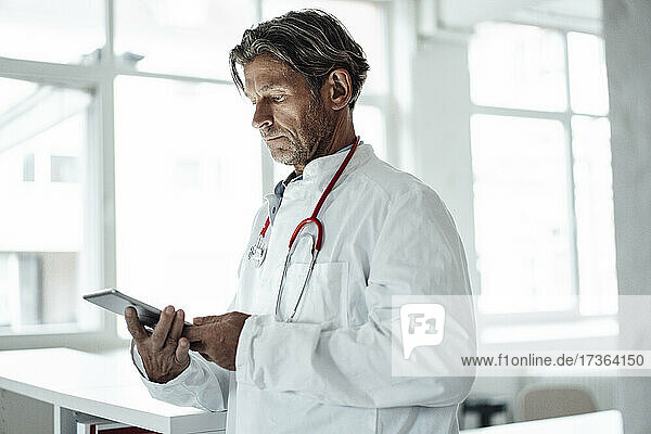 Männlicher Angestellter des Gesundheitswesens benutzt ein digitales Tablet in einer medizinischen Klinik