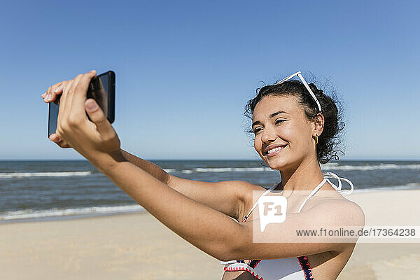 Schöne Frau nimmt Selfie durch Smartphone am Strand