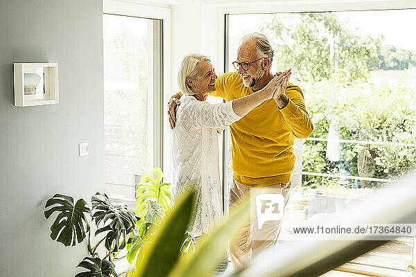 Glückliches reifes Paar tanzt zu Hause