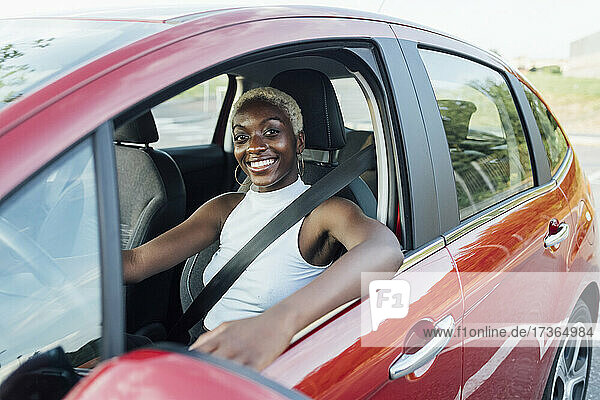 Junge Frau lächelnd während der Fahrt im Auto