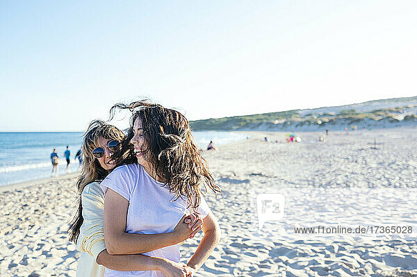Fröhliches lesbisches Paar vergnügt sich am Strand