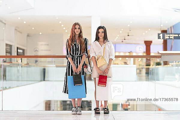Freundinnen halten eine Einkaufstasche in einem Einkaufszentrum