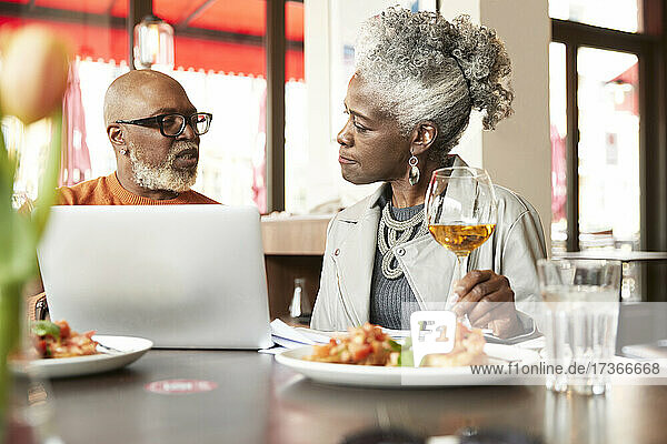 Ehepaar benutzt Laptop im Restaurant