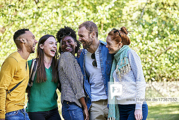 Porträt von glücklichen Freunden  die in einem öffentlichen Park für ein Foto posieren