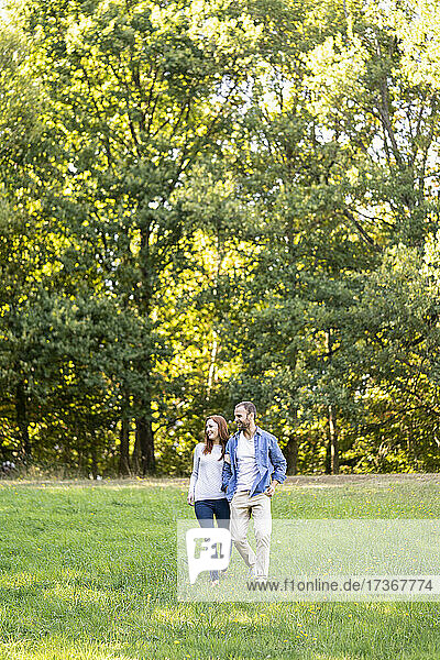Lächelndes junges Paar bei einem Spaziergang in einem Park