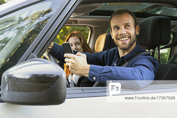 Lächelndes junges Paar genießt die Autofahrt