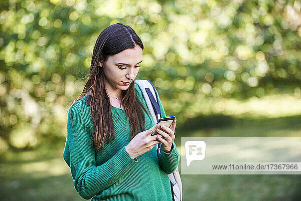 Junge Frau schreibt eine SMS auf einem Smartphone
