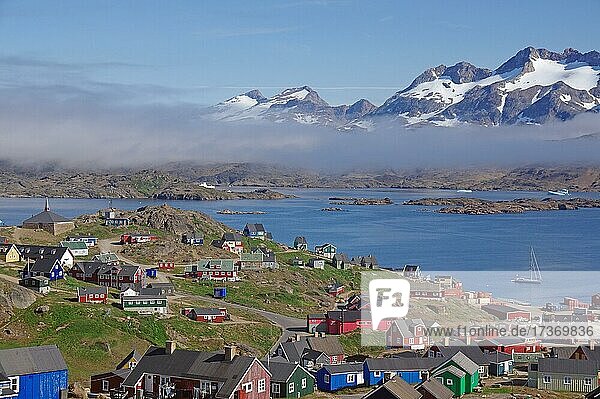 Aussicht auf bunte Häuser  Fjord mit Nebel und hohe Berge  Tasilaq  Grönland  Dänemark  Nordamerika