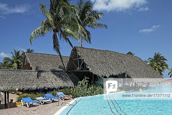 Pool  Poolbar mit Palmblätter-Dach  Sonnenliegen  Kokospalmen (Cocos nusifera) Hotel Brisas  Playa St. Lucia  Provinz Camagüey  Karibik  Kuba  Mittelamerika