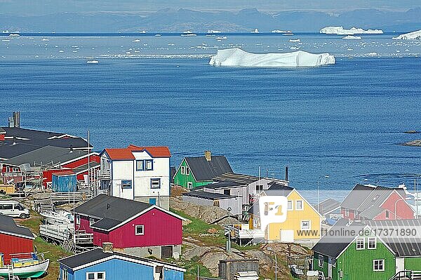 Häuser in verschiedenen Farben  Eisberge in einer Bucht vor Insel  Arktis  Ilulissat  Diskobucht  Diskoinsel  Grönland  Dänemark  Nordamerika