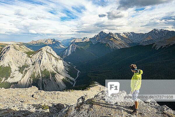 Hiker looking into the distance  mountain landscape with river valley and peaks  peaks with orange sulphur deposits  Overturn Mountain  panoramic view  Nikassin Range  Sulphur Skyline  near Miette Hotsprings  Jasper National Park  Alberta  Canada  North America