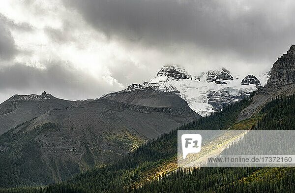 Cloudy snow-capped peaks  Mount Charlton and Mount Unwin  autumnal forest  Maligne Lake  Alberta  Canada  North America