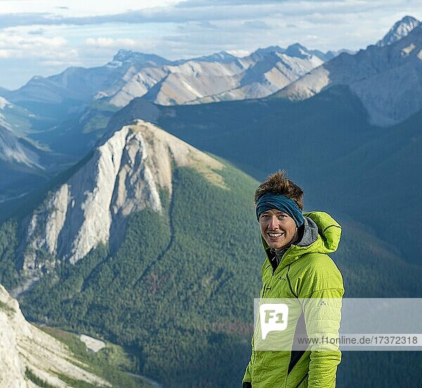 Junger Mann  Porträt  Wanderer  hinten Berglandschaft mit Flusstal und Gipfeln  Gipfel mit orangene Sulphurablagerungen  Sulphur Skyline  bei Miette Hotsprings  Jasper Nationalpark  Alberta  Kanada  Nordamerika